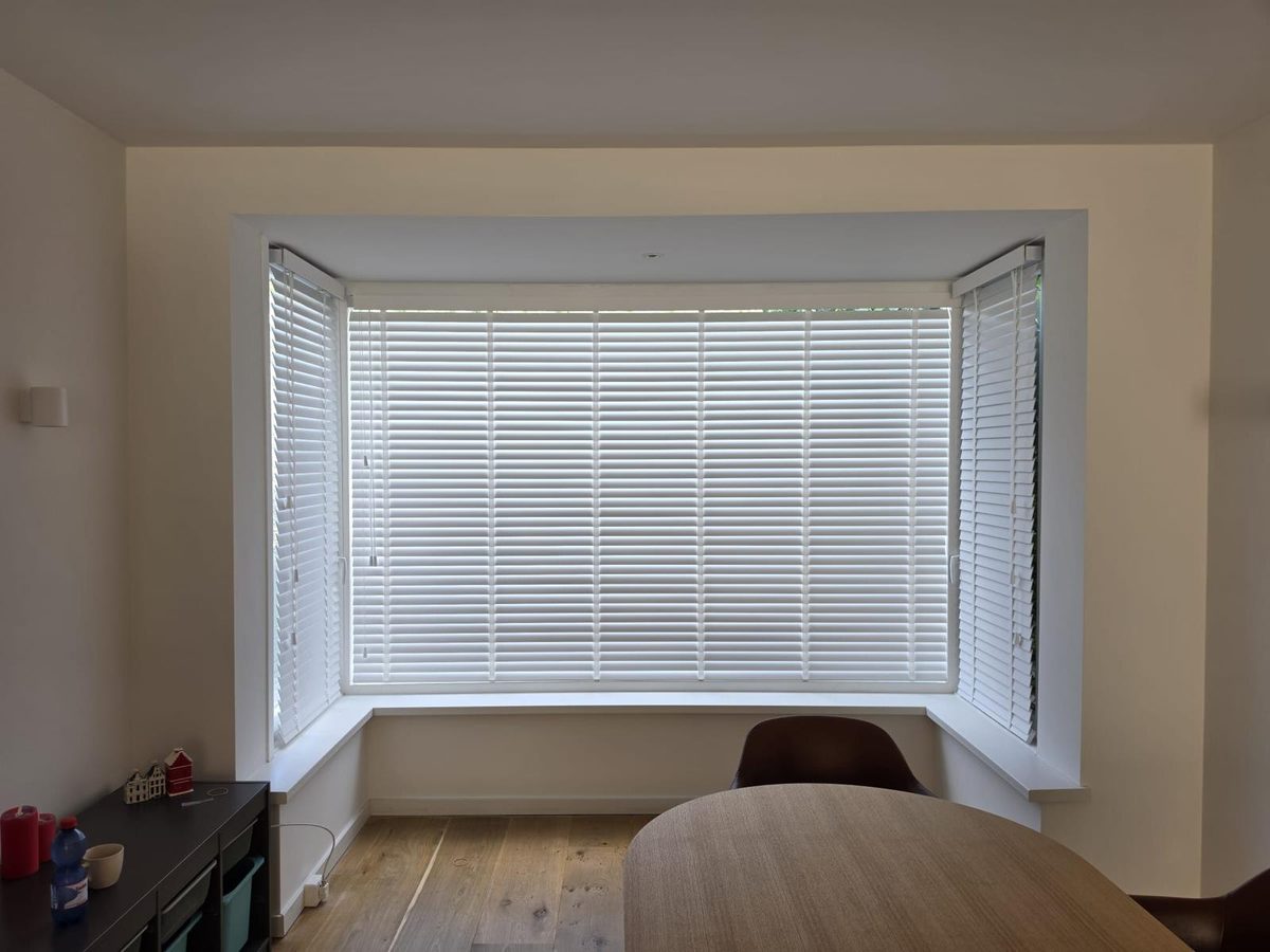 Woonkamer met witte houten jaloezieën