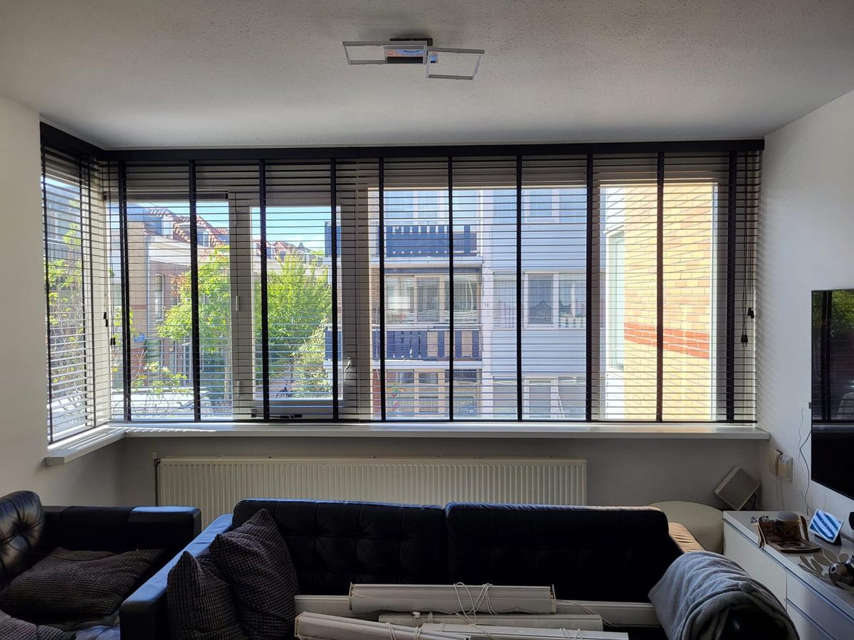 Woonkamer met zwarte houten jaloezieën
