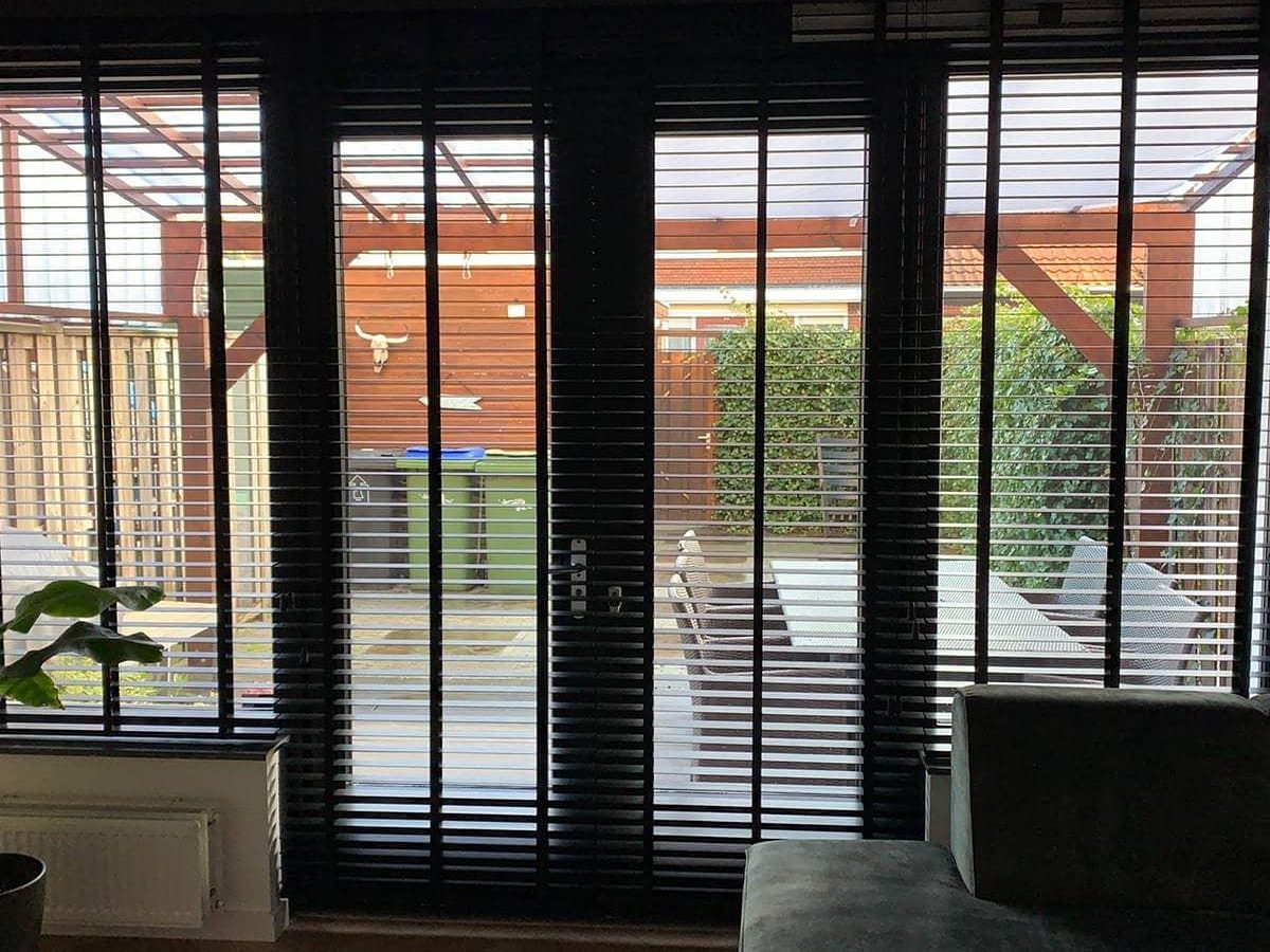 Tuindeuren met zwarte jaloezieën